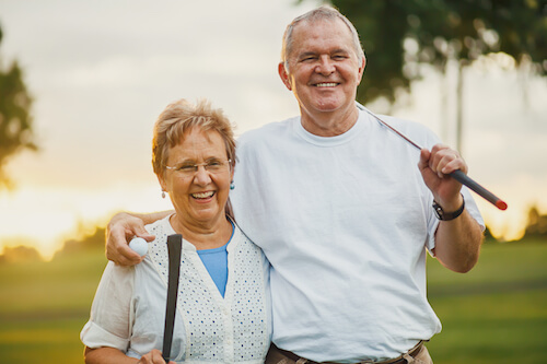 Senior couple playing golf outside