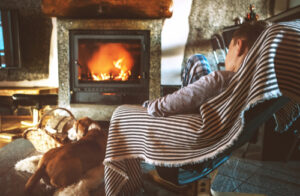 woman sitting by fireplace