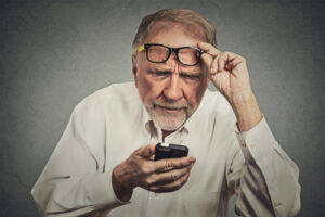 man struggling to read off of a phone